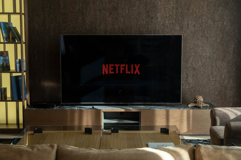 An image depicting a person using a smartphone to stream Netflix content on a TV
